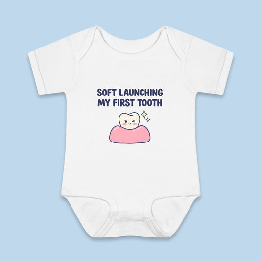 Soft Launching My First Tooth onesie – Flat on blue background