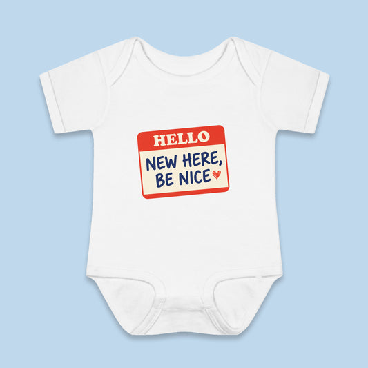 New Here, Be Nice onesie – Flat on blue background